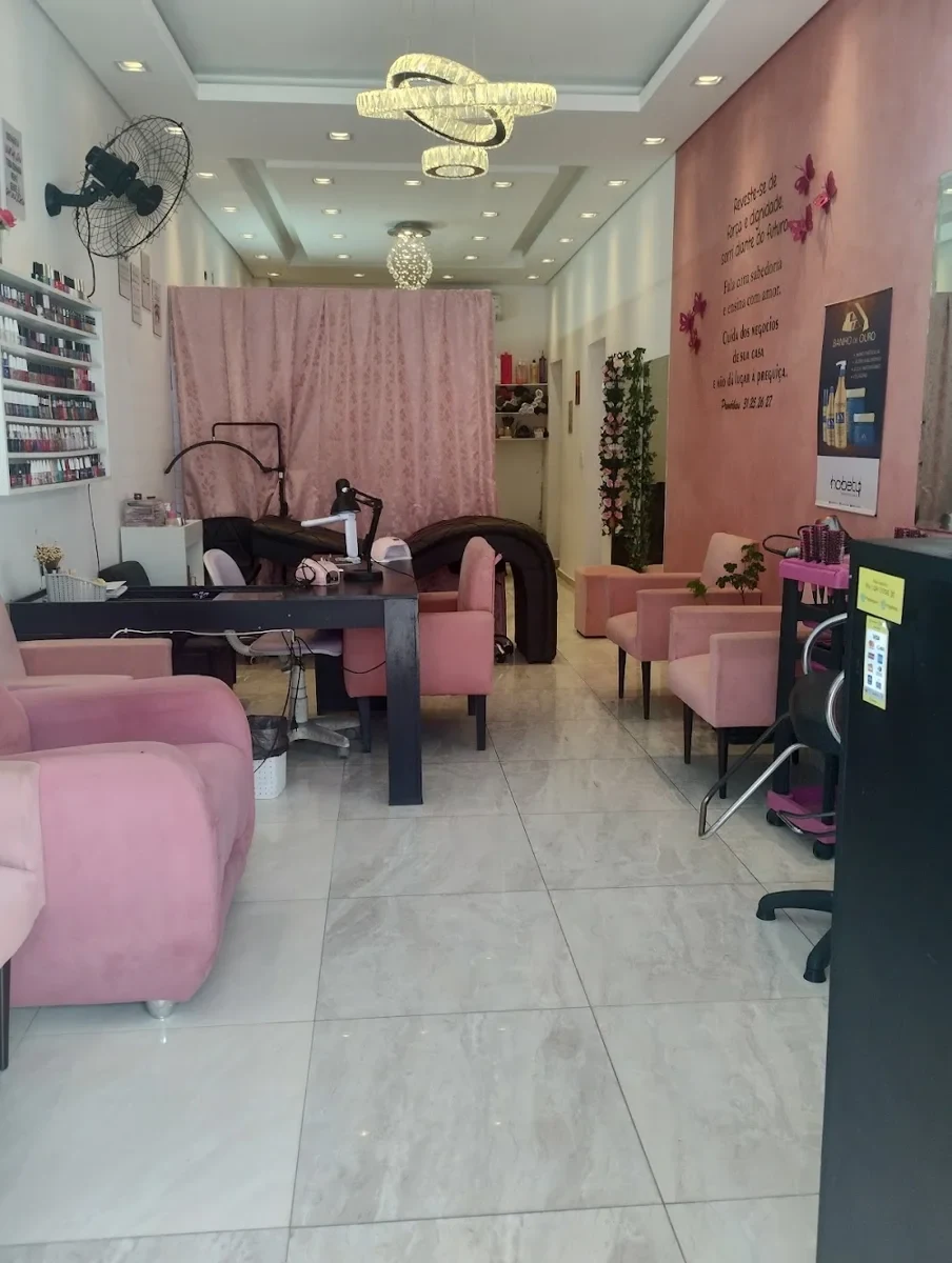 Interior do Studio Delas, com cadeiras, lavatório e decoração em rosa